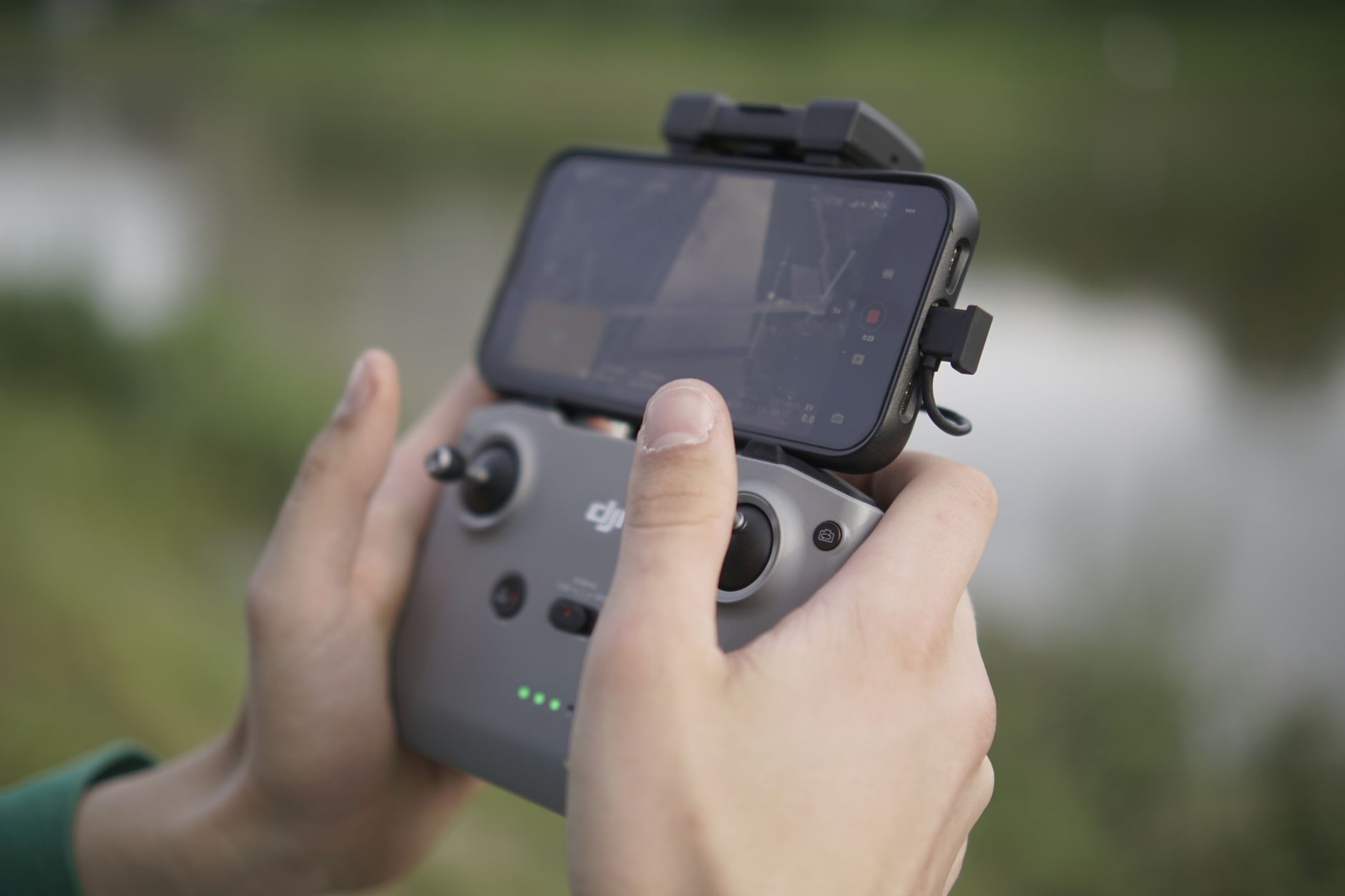 kontroler za dron sa ekranom i telefon na suncu