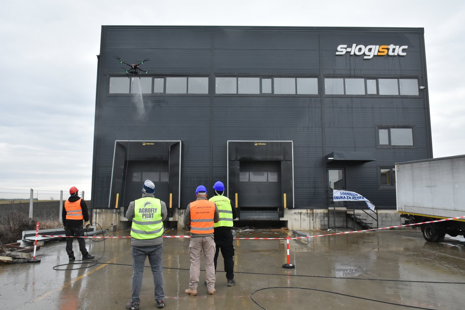 Polaznici obuke za pranje dronom ispred fasade poslovnog objekta