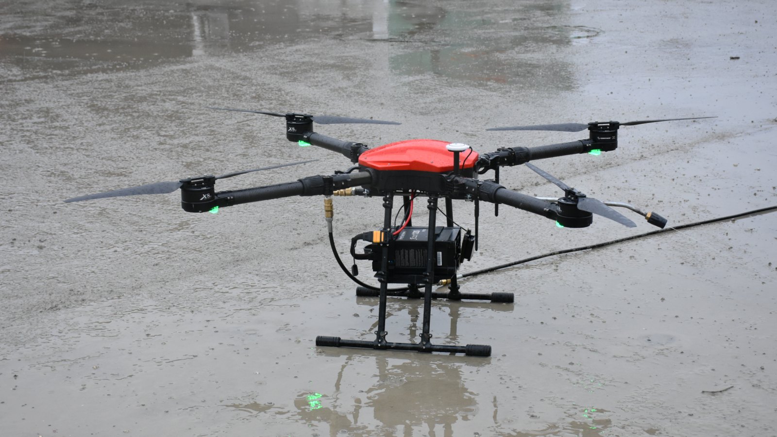 Dron za pranje sa crevom za vodu na mokroj podlozi posle rada